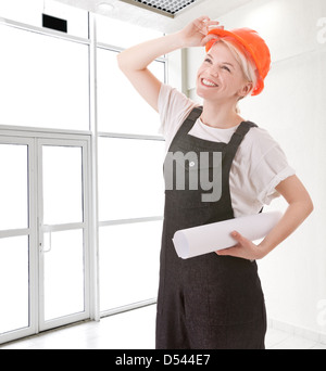 stets gut gelaunte Frau in Arbeitskleidung auf ein Office-Hintergrund Stockfoto