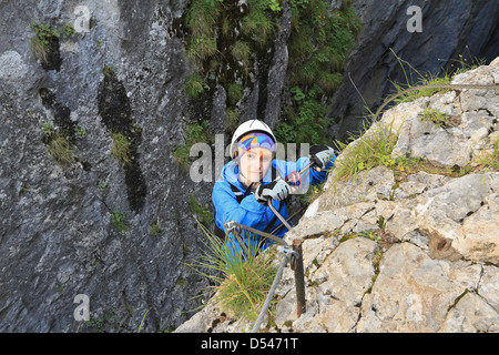 weibliche Kletterpflanze mit weißen Helm auf die via Ferrata, italienischen Dolomiten Stockfoto