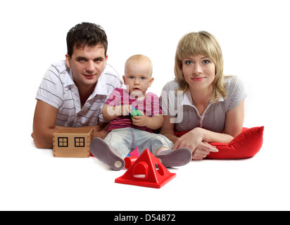 glückliche junge Familie auf dem Boden auf rote Kissen, weißer Hintergrund, Studio, isoliert Stockfoto