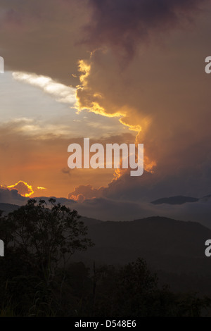 Bunte Wolken bei Sonnenuntergang über den bewaldeten Hügeln der Provinz Pahang, Malaysia Stockfoto