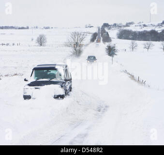 Englisch Peak District, Derbyshire, UK. 24. März 2013, Tiefschnee und verlassenen Autos auf der B5057 zwischen Darley Dale und Chesterfield. Starker Schneefall und starkem Wind wurden Triebschnee, die Straße zu blockieren verursacht. Stockfoto