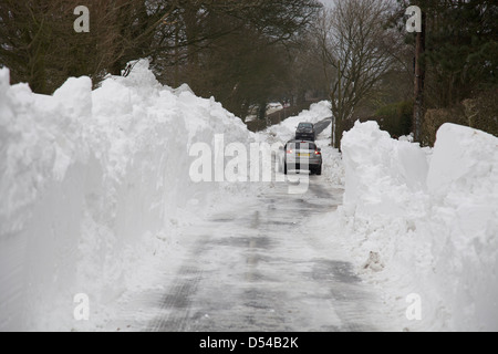 Ein Auto Umkehr durch tiefen Schnee driftet auf einer Landstraße in Lancashire Stockfoto