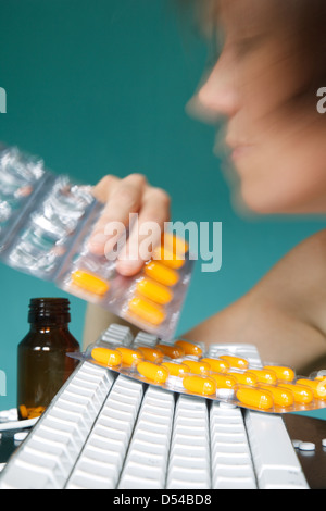 Berlin, Deutschland, nimmt eine Frau Tabletten bei der Arbeit Stockfoto