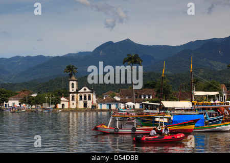 Hafen Sie mit Ausflugsschiffe, die Capela de Santa Rita Kirche am Rücken. Paraty, Kleinstadt in Rio de Janeiro, Brasilien Stockfoto