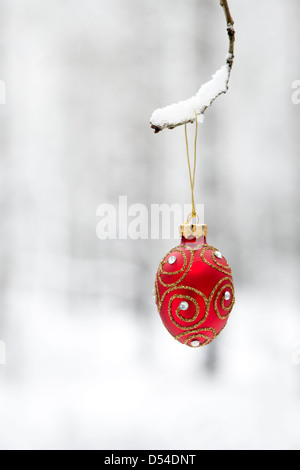 Christbaumschmuck / Kugeln hängen an einem Ast im Schnee Stockfoto