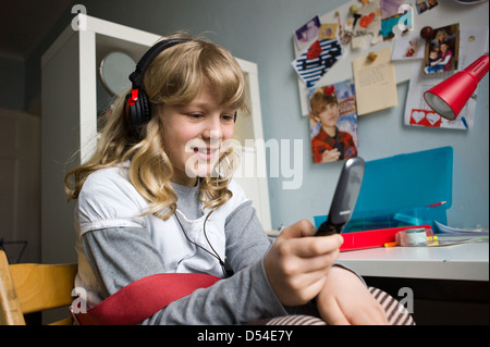 Berlin, Deutschland, ein Mädchen schreibt SMS und hört Musik Stockfoto