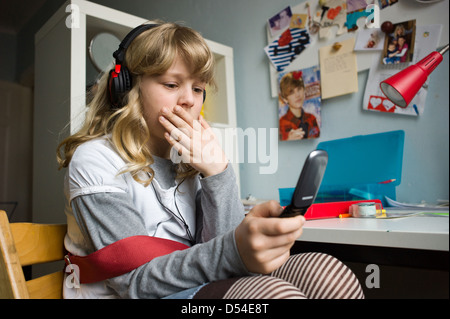 Berlin, Deutschland, ein Mädchen schreibt SMS und hört Musik Stockfoto