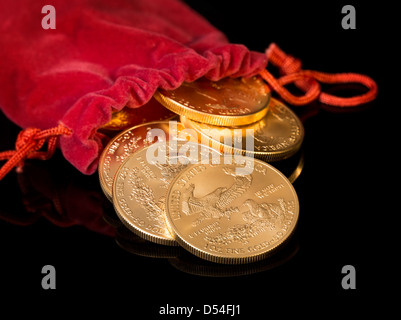 Stapel von gold Eagle eine Feinunze Gold-Münzen vom US-Finanzministerium Minze Gießen aus rotem Samt Geldtasche Stockfoto