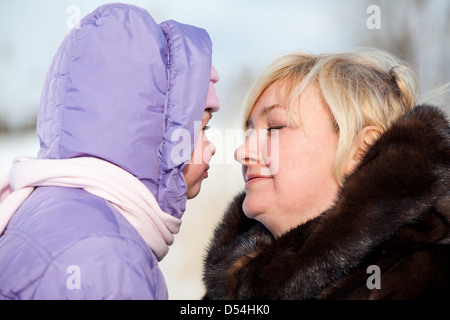 Liebevolle Mutter mit Kleinkind im Winter warme Kleidung sind zusammen Stockfoto