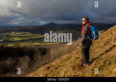 Weibliche Wanderer an den Hängen des Skirrid mit der Zuckerhut in die Ferne, Wales, UK Stockfoto