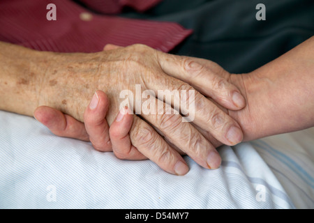 Deutschland, hält die Hand von einer Krankenschwester die Hand eines sterbenden Stockfoto