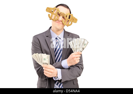 Ein junger Mann Dollarzeichen Brille trägt und hält US-Dollar, die isoliert auf weißem Hintergrund Stockfoto