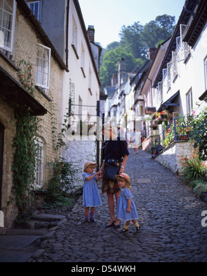 Mutter und Kinder zu Fuß hinunter gepflasterten Hauptstraße in Clovelly, Torridge District, Devon, England, Vereinigtes Königreich Stockfoto