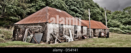 Alter Traktor sitzt außerhalb einer alten Scheune auf einem Croft in den schottischen highlands Stockfoto