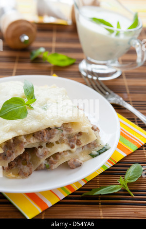 Fleisch-Lasagne mit geriebenen Mozzarella und Basilikum, Nahaufnahme Stockfoto