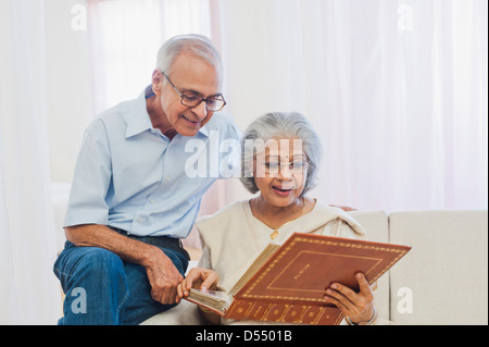 Älteres paar sitzen auf dem Sofa und beobachtete Fotoalbum Stockfoto