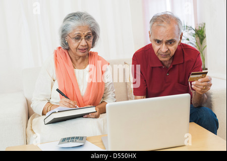 Älteres Paar, die Prüfung der Rechnungen auf einem laptop Stockfoto