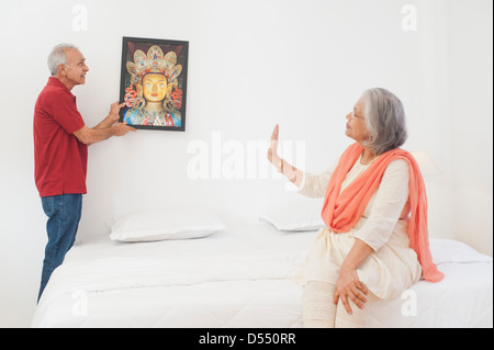 Mann ein Gemälde an der Wand hängen Stockfoto