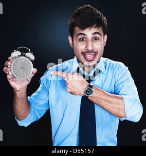 Geschäftsmann mit Wecker Stockfoto