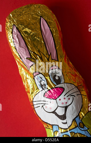 Folie verpackt Schokolade Osterhase setzen auf rotem Grund Stockfoto