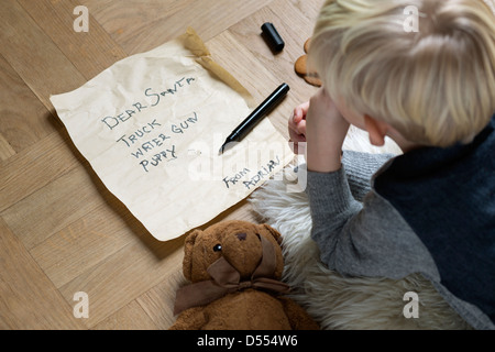 Junge schreiben Wunschzettel für den Weihnachtsmann Stockfoto