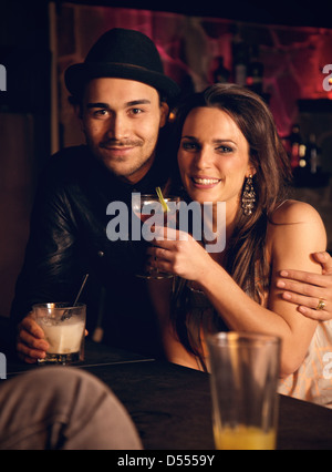 Attraktives Paar mit Wein genießen Sie ihre Drinks an der bar Stockfoto