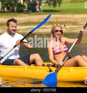 Junges Paar Kajakfahren im Sommer in der Sonne Urlaub Stockfoto