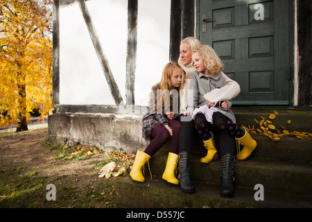 Mutter und Töchter sitzen im freien Stockfoto