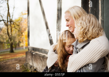 Mutter und Töchter sitzen im freien Stockfoto