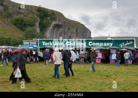 Große Masse der Menschen an der Landschaft showground wandern im Regen durch Handel Stative & Exponate an belebten Landwirtschaft zeigen - Kilnsey, Yorkshire, England, Großbritannien Stockfoto