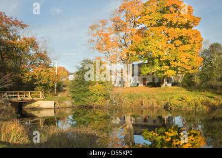 Cape Cod Stil Haus Spiegelbild im Teich im Herbst Bristol, Maine. Stockfoto