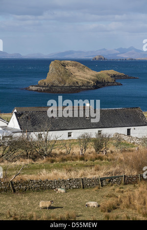 Traditionelle weiß getünchten Croft mit Tulm Insel und der Isle of Lewis im Hintergrund, Isle Of Skye, Schottland Stockfoto