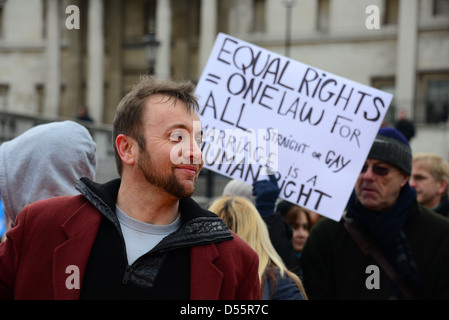 Ein Demonstrant hält ein Plakat geschrieben "Gleichberechtigung = ein Gesetz für alle, gerade oder Homosexuell. Die Ehe ist ein Menschenrecht ", in Trafalgar Stockfoto