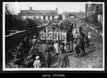 Britische Truppen kommen in einem Dorf an, das vor kurzem während des Ersten Weltkriegs eingenommen wurde. Dieses Foto zeigt das Gefühl des Sieges und die logistische Anstrengung, die mit dem Vormarsch durch feindliches Territorium während des Konflikts verbunden ist. Stockfoto
