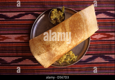 Masala Dosa oder Masala Dosis eine fermentierte Crêpe aus Reis Teig und schwarze Linsen mit Chutneys und Sambar serviert. Süd-Indien Stockfoto