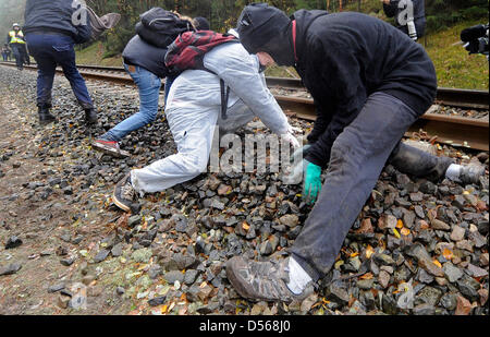 Anti-atomare-Aktivisten klar Kies unter den Bahngleisen während einer Protestkundgebung gegen den Castor nuklearen Transport entlang der Bahnstrecke in der Nähe von Leistade, zwischen Lüneburg und Dannenberg, Deutschland, 7. November 2010. 12. Lieferung von Atommüll aus der französischen Wiederaufbereitungsanlage in La Hague ist etwa das Zwischenlager für Atommüll in G Stockfoto