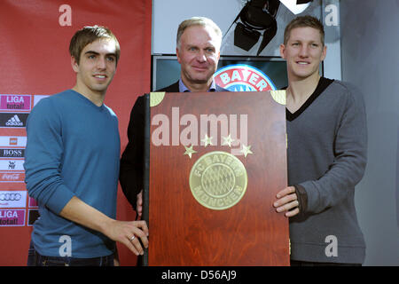 Bayern Spieler Philipp Lahm (L) und Bastian Schweinsteiger (R) und Vorsitzender des FC Bayern München Karl-Heinz Rummenigge die größte Bayern München-Chronik je gemacht während einer Pressekonferenz in München, Deutschland, 10. November 2010 präsentieren. Nach FC Bayern München das Buch mit dem Titel 4 Sterne - 111 Jahre 70x50cm groß und wiegt ca. 30 kg - so dass es die größte so Stockfoto