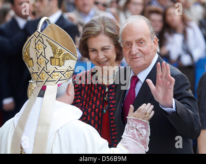 Spaniens König Juan Carlos (R) und Queen Sofia (C) treffen sich Palma de Mallorcas Bischof vor dem Besuch einer östlichen Sonntagsmesse. Stockfoto