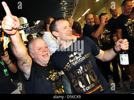 Norbert Vettel (L), Vater des deutschen Fahrer Sebastian Vettel von Red Bull, feiert seinen Sohn gewinnen in der Titel-entscheidende 2010 Formel1 Saisonfinale auf Rennstrecke Yas Marina Circuit in Abu Dhabi, Vereinigte Arabische Emirate, 14. November 2010. Vettel gewann das Rennen und die Weltmeisterschaft. Foto: JENS Büttner Stockfoto