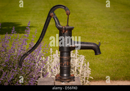 Gusseisen garten Wasserpumpe am Kensington Roof Gardens oberhalb der  Kensington High Street entfernt. Blüten in Wasser. Grüne Büsche & Mauer  Stockfotografie - Alamy