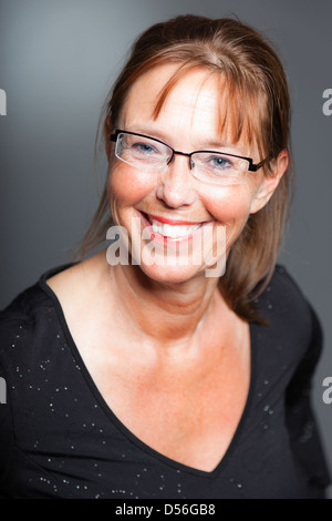 Glückliche spontane Frau. Das Tragen einer Brille. Studio gedreht. Stockfoto