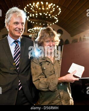 Englische Tastatur Spieler Keith Emerson (R) lächelt seine Music Prize 2010 in Frankfurt und der Frankfurter Leiter der Kulturabteilung Felix Semmelroth (L) in Frankfurt Main, Deutschland, 23. März 2010. Emerson, Keyboarder und Gründungsmitglied des progressive Rock-Band "Emerson, Lake & Palmer" mit FFrankfurt Music Prize 2010, am Vorabend der 2010 Frankfurter Musikmesse ausgezeichnet ist, die Stockfoto