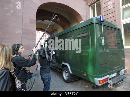 Ein Kamerateam steht wie ein Gefängnis-Transporter mit TV-Moderator und Meteorologe Joerg Kachelmann (unsichtbaren) den Hof des Amtsgerichts in Mannheim, Deutschland, 24. März 2010 verlässt. Kachelmann wurde nach der Sorgeberechtigten Richter für die Überprüfung der seiner Haftanordnung berufen. Der 51-jährige ist derzeit in Haft über Vorwürfe geführt, dass er seine ehemalige Freundin vergewaltigt hatte. P Stockfoto