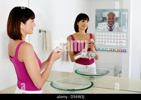 Gemischte Rassen Frau mit Computer im Spiegel Stockfoto