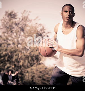 Afrikanische amerikanische Mann spielen Basketball auf Platz Stockfoto