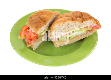 Eine Weizen sperrige Rollen Tofu fleischlose Truthahn-Sandwich mit Salat Tomaten und Mayonnaise in der Mitte auf einer grünen Platte geschnitten. Stockfoto