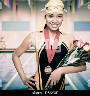 Gemischte Rassen Schwimmer mit Medaille und Blumen Stockfoto