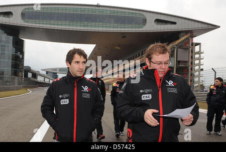 Deutsche Formel1-Fahrer Timo Glock von Virgin Racing (L) und ein Team-Mitglied Fuß über dem Shanghai International Circuit in Shanghai, China, 15. April 2010. Die Formula One Chinese Grand Prix statt findet am 18. April 2010. Foto: Peter Steffen Stockfoto