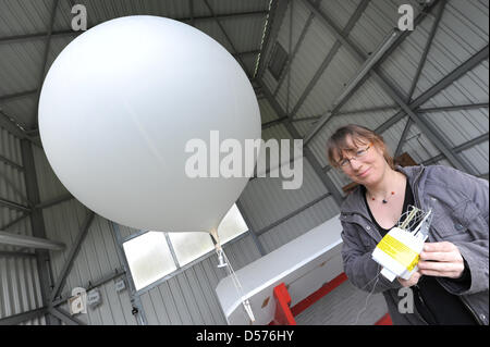 Ein Mitarbeiter der deutschen meteorologischen Service Provider (DWD) bereitet einen Wetterballon mit einer Radiosonde aus Gründen der Wetterstation Greifswald, Deutschland, 20. April 2010. Der DWD kann immer mehr Wetterballons bis in der Luft wegen der Vulkanasche-Wolke. Die Zahlen der Land breit neun Radiosonde Stationen wurde verdoppelt. Seit 16. April 2010, der Ballon-Sonden in Stockfoto