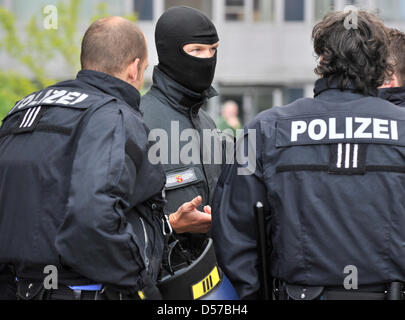 Mummed Offiziere des deutschen spezielle Polizei (SEK) sichern den Eintritt in einen Sicherheitsbereich, während der Angeklagte in das Gebäude am Bezirk Hof in Kaiserslautern, Deutschland, 4. Mai 2010 getrieben wird. Das Amtsgericht bekanntgeben, das Urteil über 4. Mai 2010 in einem Mordfall, in der zwei Männer der Motorrad Club "Hells Angels" wird vorgeworfen, der Chef der getötet haben '' Ou Stockfoto